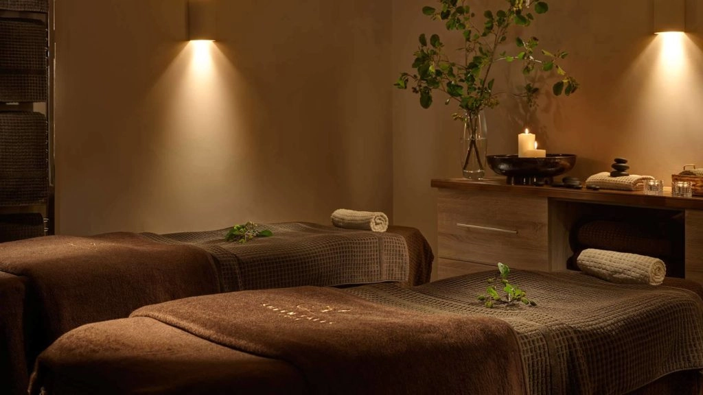 Luxurious spa room with soft lighting, plush massage beds, and calming candles, perfect for relaxation and rejuvenation.