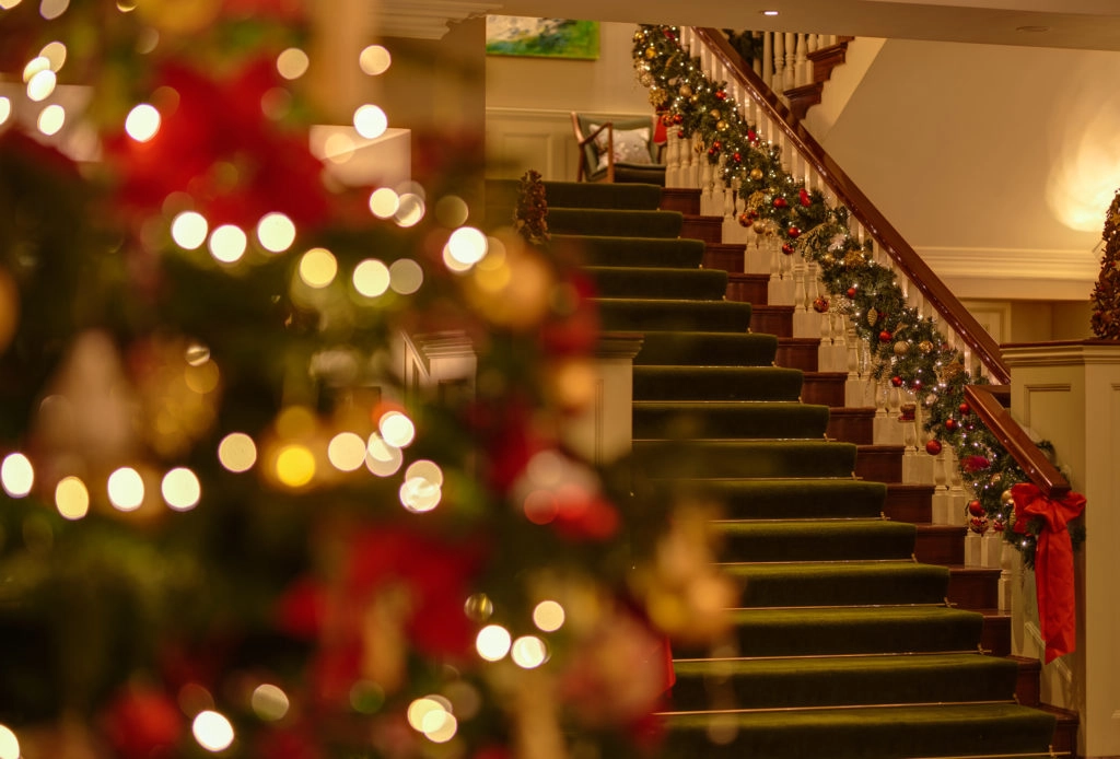 Main staircase at Sheen Falls Lodge decorated with festive garland and Christmas tree