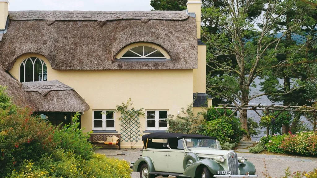 Cosy thatched cottage hotel, lush gardens, classic car. Enjoy countryside charm, serene views by the lake.