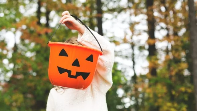 child-holding-jack-o-lantern