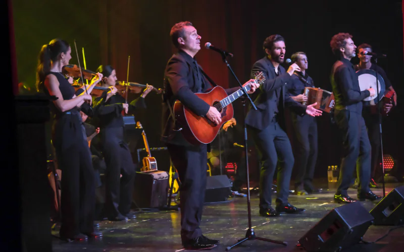 Live band performance in elegant hotel venue with musicians playing guitars and violins, creating a vibrant evening atmosphere.