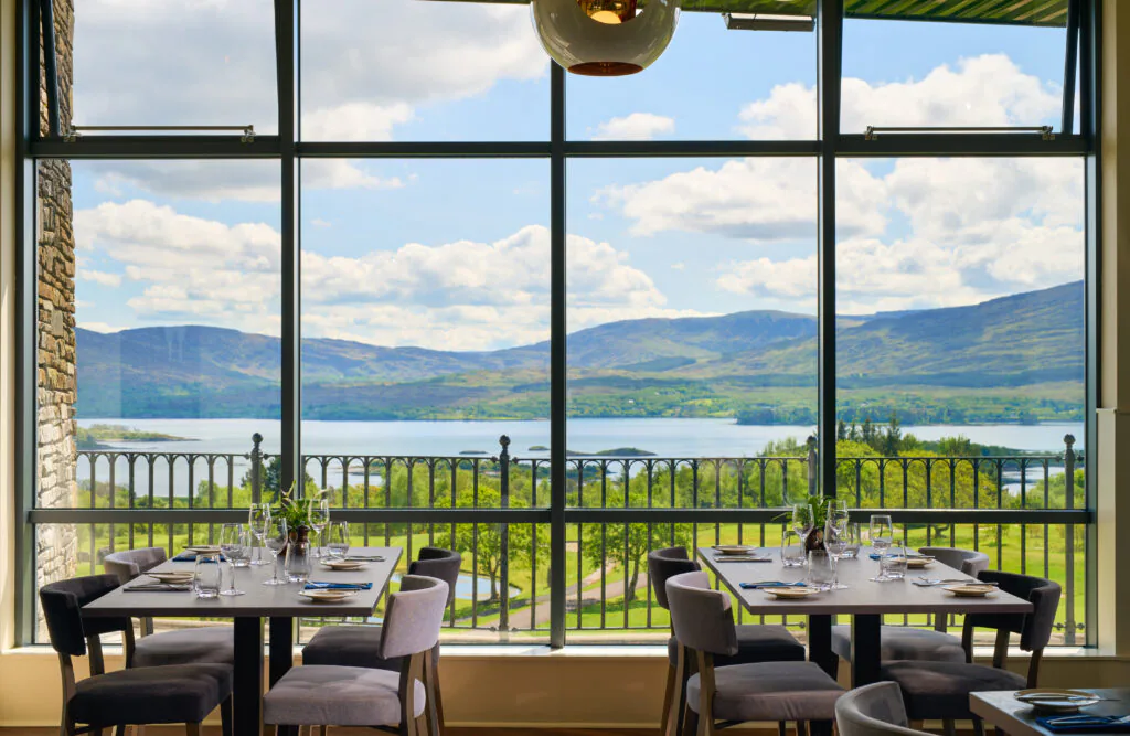 Scenic dining experience with panoramic lake and mountain views at stylish hotel restaurant, featuring elegant table settings.
