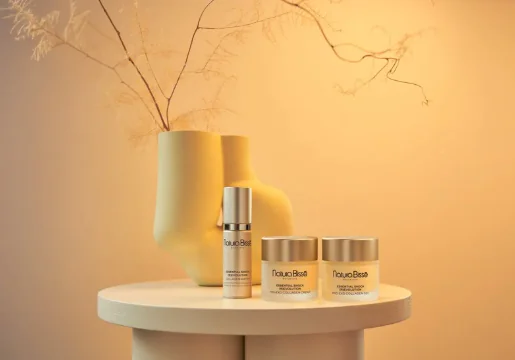 Luxurious skincare products on elegant table at hotel spa, featuring calming decor with warm, inviting lighting.