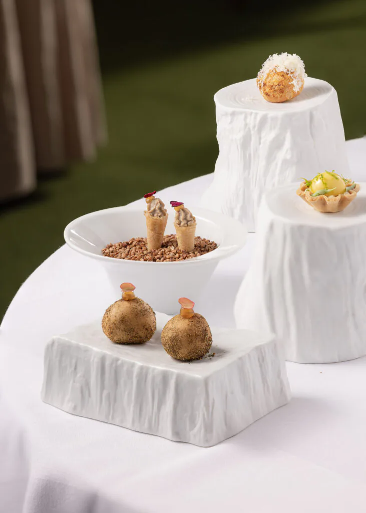 Gourmet appetisers on elegant ceramic displays at luxury hotel, showcasing exquisite dining experience and refined cuisine.