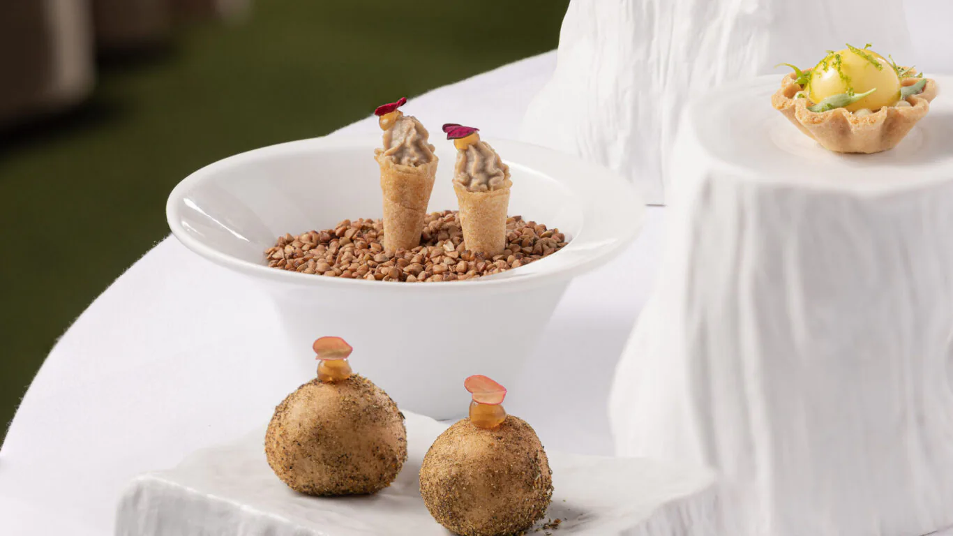 Gourmet appetisers on elegant ceramic displays at luxury hotel, showcasing exquisite dining experience and refined cuisine.