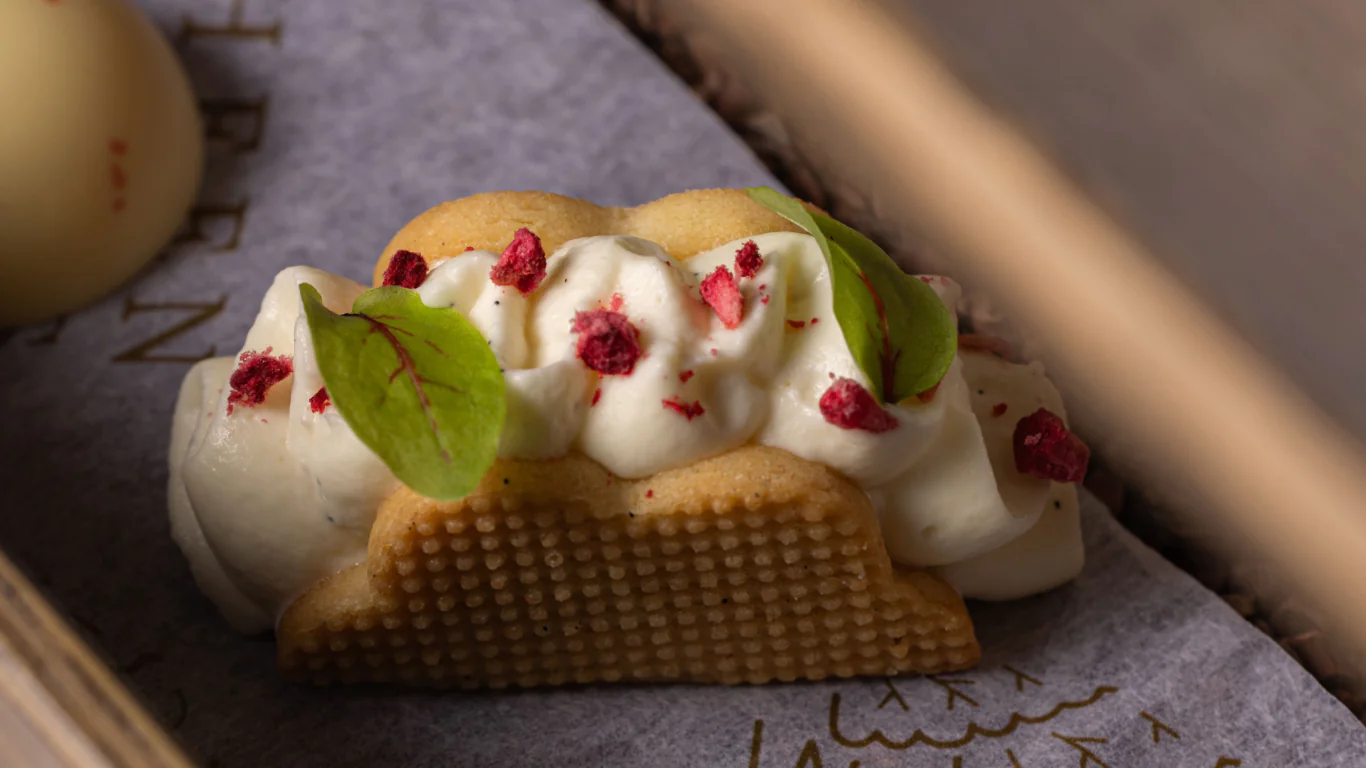 Sumptuous cream-filled pastry with berry and mint garnish on elegant serving tray at luxury hotel dining.