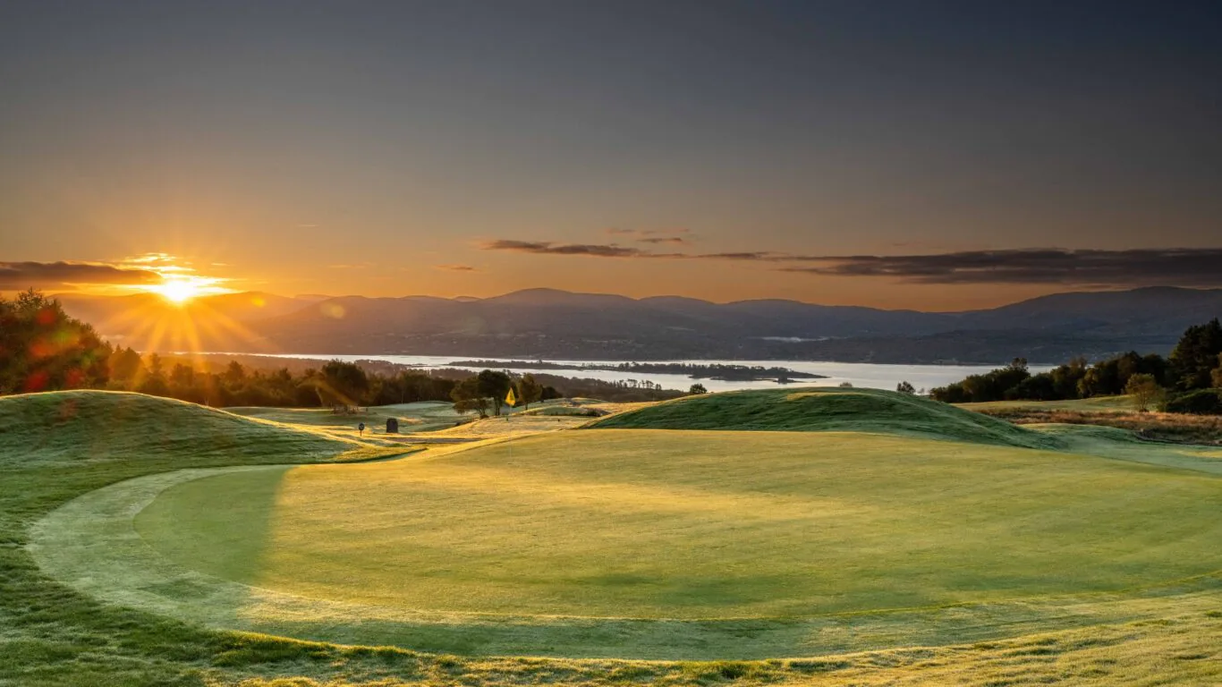 Relaxing sunset view over lush green golf course, offering scenic lake backdrop, inviting for a tranquil leisure stay.
