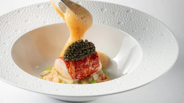 Luxurious lobster dish with caviar and foam, served on elegant tableware at the hotel's fine dining restaurant.