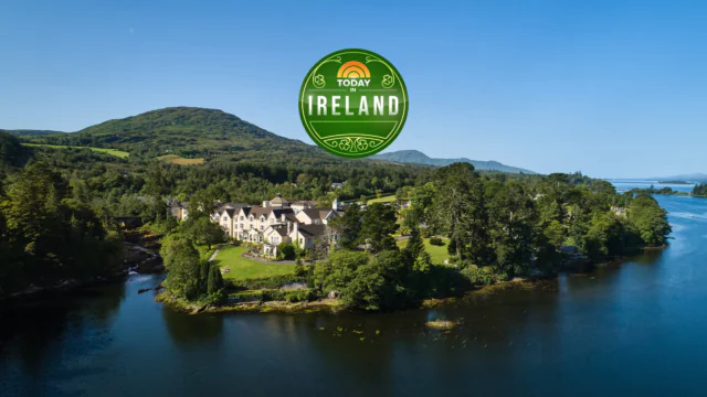 Luxurious Irish hotel nestled in lush greenery by a tranquil lake, offering a serene escape with stunning mountain views.