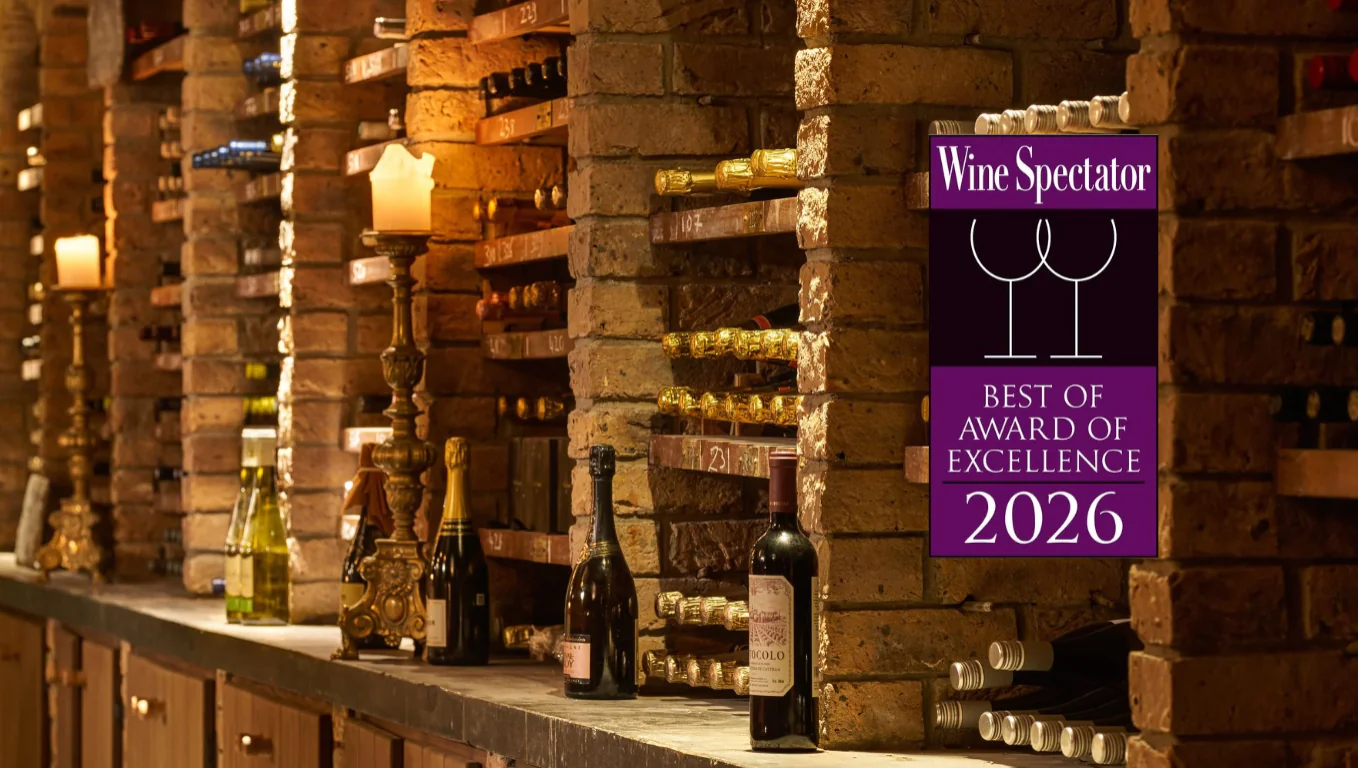 Elegant hotel wine cellar with award-winning selection, vintage bottles, and candlelit ambiance for a luxurious experience.
